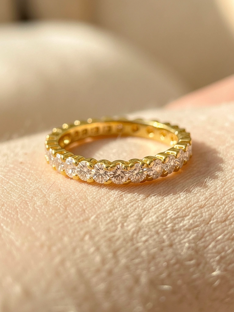 Aliança de ouro amarelo cravejada de diamantes brilhantes em toda a volta, iluminada por luz natural suave com fundo desfocado.