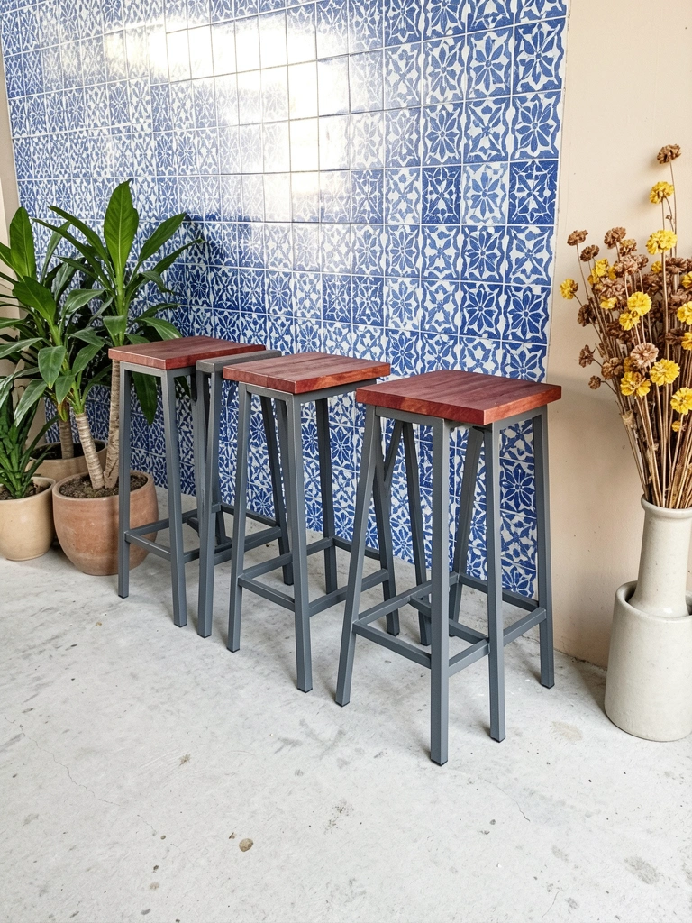 Banqueta de ferro e madeira com assento circular ao lado de vaso com planta em ambiente claro.