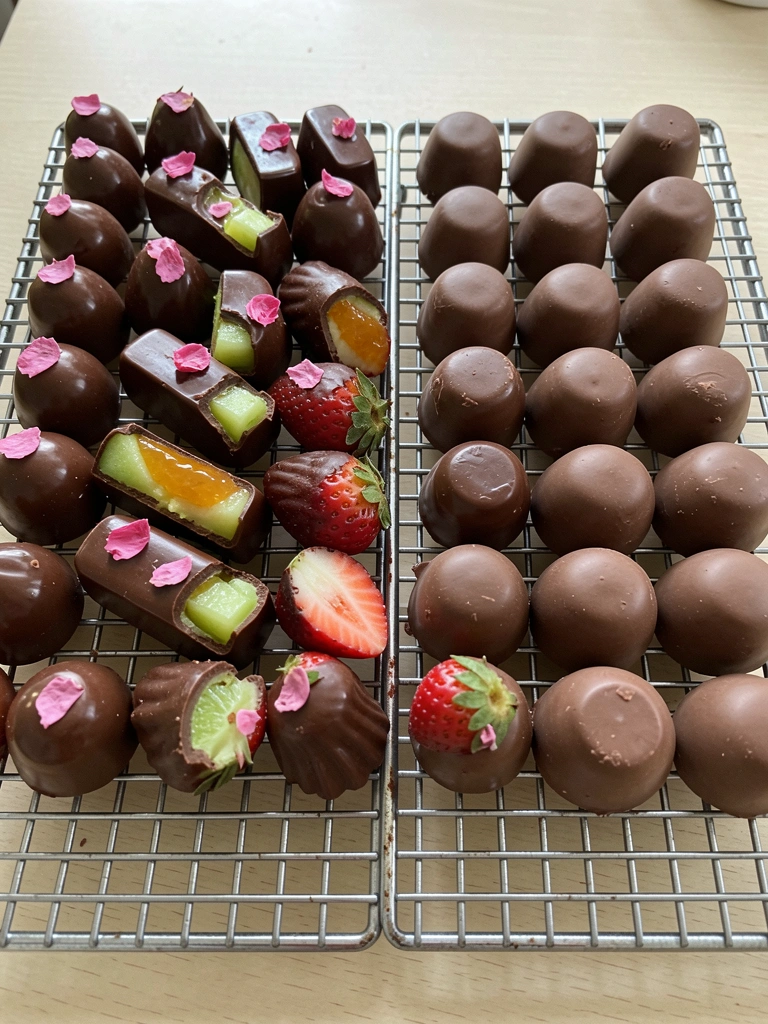 Dois pratos sobre mesa branca: um com doces finos decorados e outro com doces simples, um ao lado do outro.