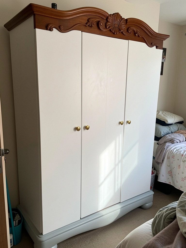 Guarda-roupa branco com portas de moldura e puxadores dourados.