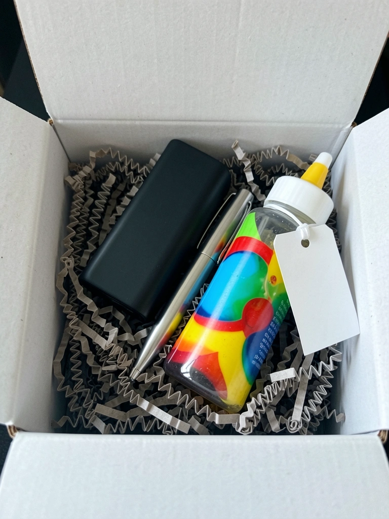 Power bank, caneta e squeeze personalizados com logotipo sobre uma mesa de madeira.