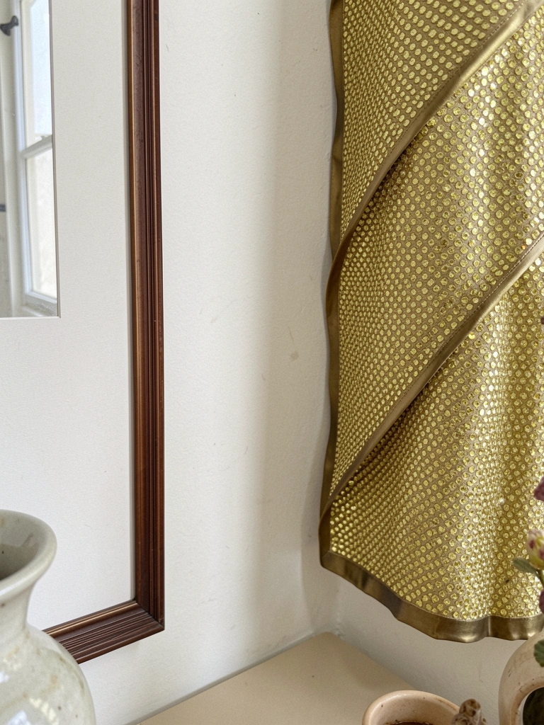 Painel decorativo com manta de strass, molduras e vasos em ambiente interno