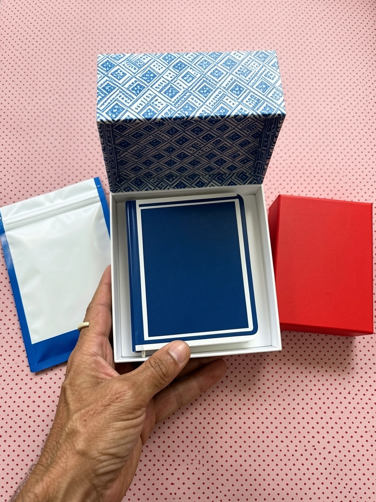 Caixa de papelão aberta com caneca de cerâmica e meias estampadas sobre mesa de madeira.